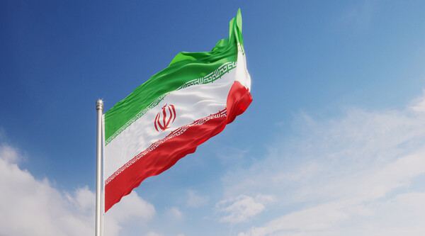 Iranian Flag Waving With Wind Over Blue Sky